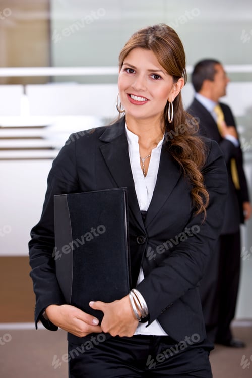 Preview: Business Woman Standing At An Office Holding A Portfolio