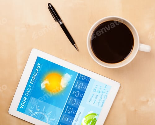 Preview: Workplace With Tablet Pc Showing Weather Forecast And A Cup Of Coffee On A Wooden Work Table