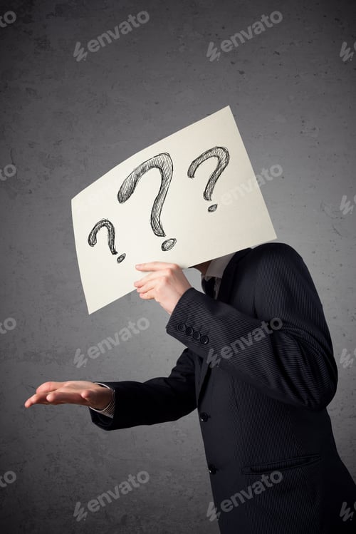 Preview: Businessman Holding A Paper With Drawed Question Marks On It In Front Of His Head