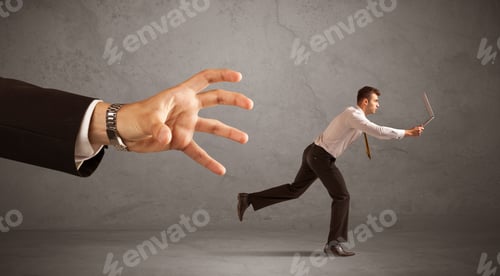 Preview: Young Miniature Businessman Running From A Big Hand With Grey Background