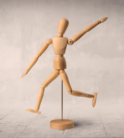 Preview: Wooden Mannequin Posed In Front Of A Greyish Background
