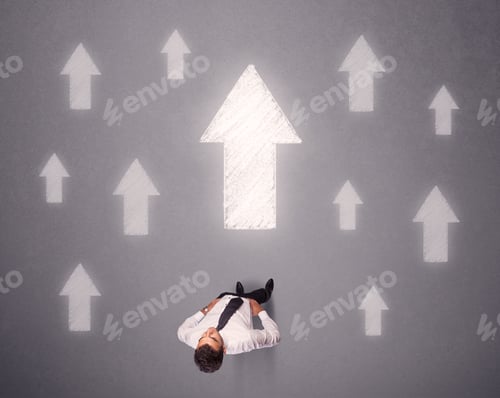 Preview: Young Contemplating Businessman Stands In Front Of White Arrows