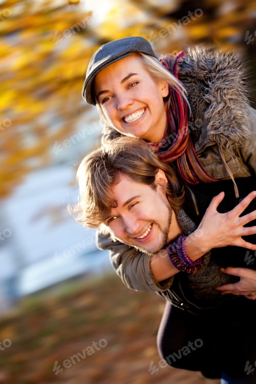 Preview: Playful Couple With A Man Giving A Piggyback Ride To His Girlfriend Outdoors