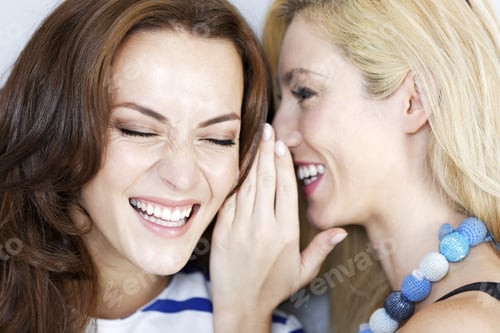 Preview: Two Young Friends Whispering To Each Other Expressing Surprise
