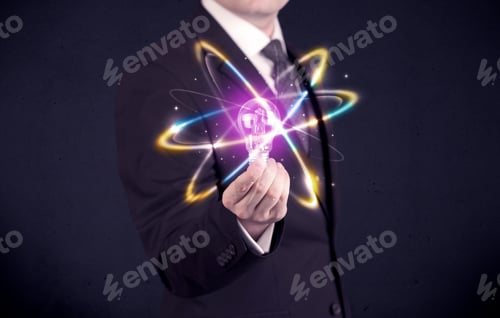 Preview: A Classy Businessman Holding A Colorful Light Bulb With Shining Circles In Front Of Dark Background