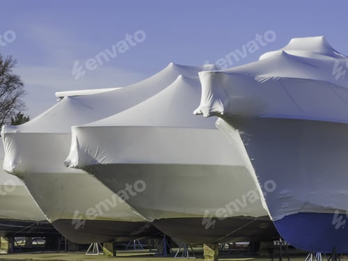 Preview: Waiting For Nice Weather Is Part Of A Lifestyle: Bows Of Shrink-Wrapped Yachts In Boatyard On A