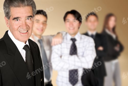 Preview: Friendly Business Man Smiling With His Colleagues Blurred In The Background