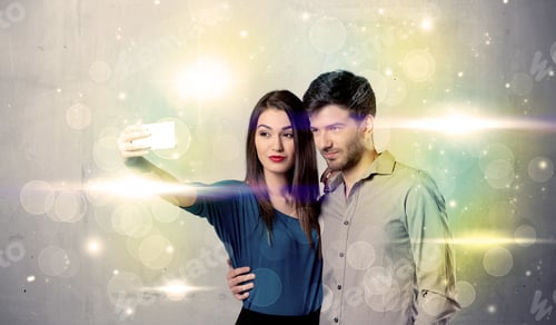 Preview: A Fresh Happy Couple Taking Selfie Photo With Mobile Phone In Front Of Colorful Lights Glitter Wall