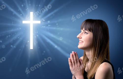Preview: Young Woman Praying On A Blue Background With A Sparkling Cross Above Her