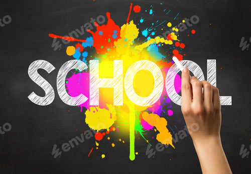 Preview: Female Hand Holding White Chalk In Front Of A Blackboard With School Written On It And A Colorful