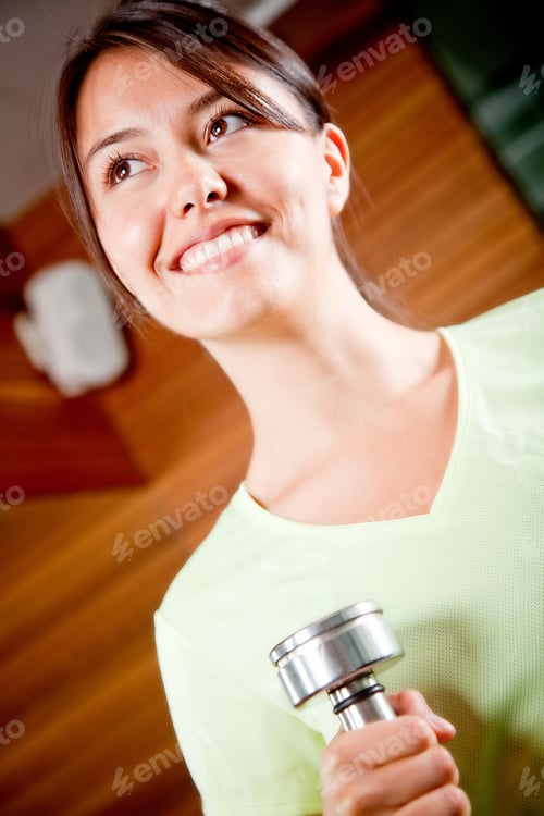 Preview: Woman At The Gym Lifting A Free-Weight And Smiling