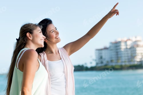 Preview: Portrait Of Two Happy Girls Pointing Away And Smiling