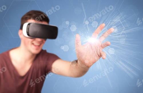 Preview: Young Impressed Man Wearing Virtual Reality Goggles With Blue Hexagons Around Him
