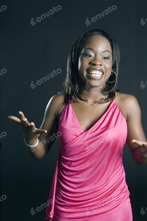 Preview: Pretty Young African-American Woman In Pink Outfit Stands Gesturing And Smiling