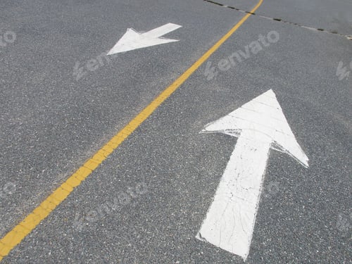 Preview: White Arrows Pointing In Opposite Directions On Street