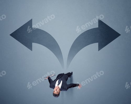 Preview: Young Smart Businessman Standing In Front Of Two Arrows Potinting To Different Ways Contemplating A