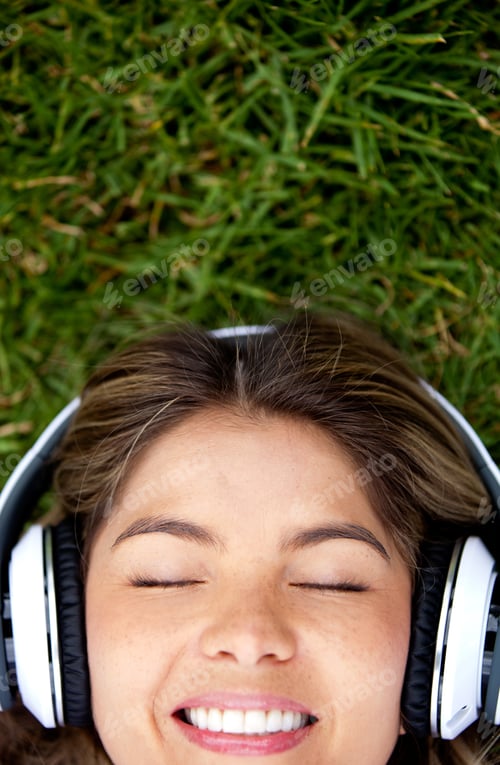 Preview: Woman Lying On The Grass With Headphones