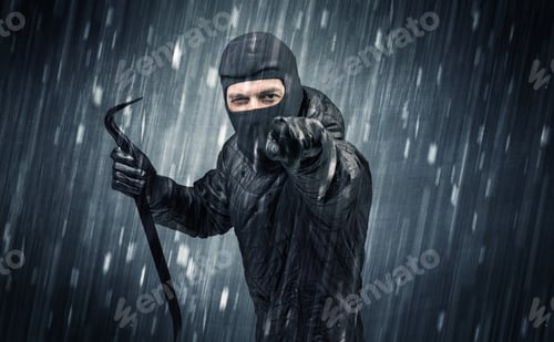 Preview: Burglar In Action In Black Clothes With Rainy Concept.