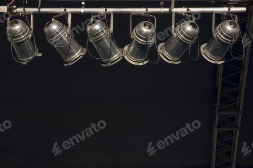 Preview: Six Stage Lights Hanging In Sunlight By Dark Wall And Ladder
