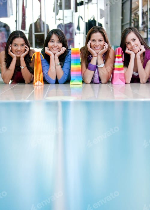Preview: Beautiful Shopping Girls Lying On The Floor In A Mall With Some Bags