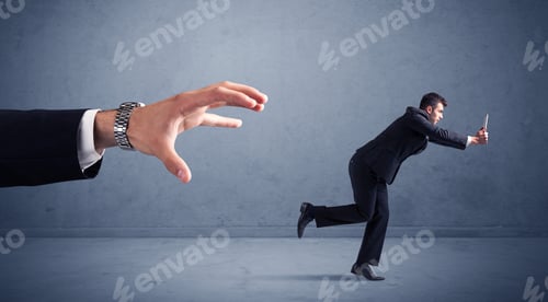Preview: Young Miniature Businessman Running From A Big Hand With Blueish Background