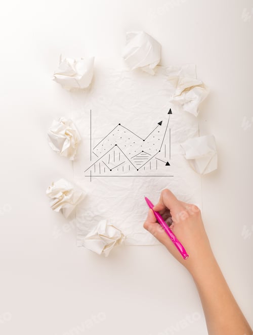 Preview: Female Hand Next To A Few Crumpled Paper Balls Drawing A Progress Chart