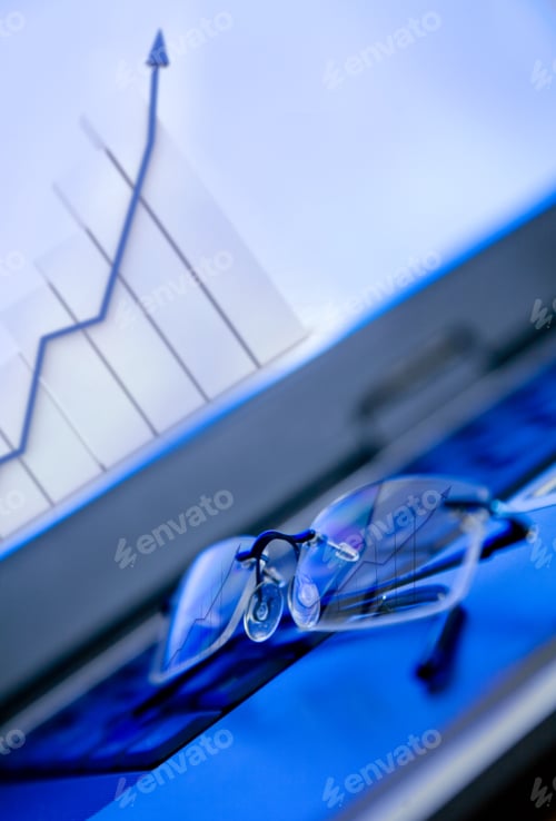 Preview: Glasses On Laptop Showing A Growth Financial Graph On The Screen - Focus Is On The Graph Reflection