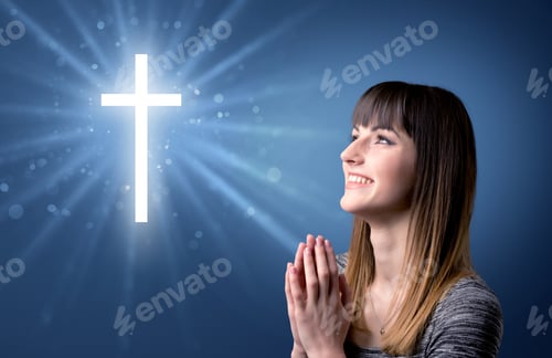 Preview: Young Woman Praying On A Blue Background With A Sparkling Cross Above Her