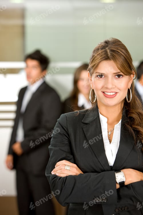 Preview: Business Woman In An Office Environment With People Working Behind Her