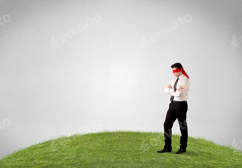 Preview: Young Blindfolded Businessman Steps On A Patch Of Grass