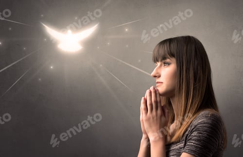 Preview: Young Woman Praying On A Grey Background With A Sparkling Bird Above Her