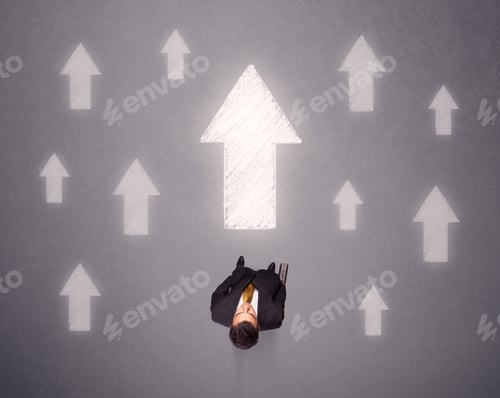 Preview: Young Contemplating Businessman Stands In Front Of White Arrows