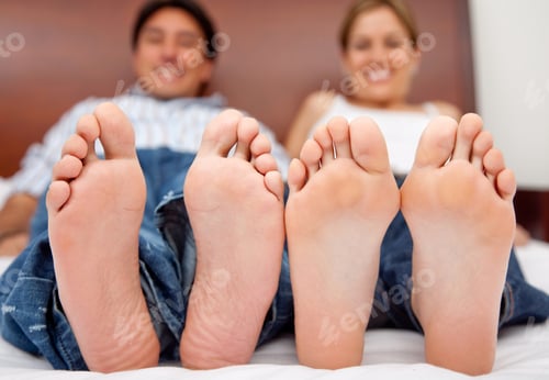 Preview: Happy Couple Lying On The Bed Barefoot