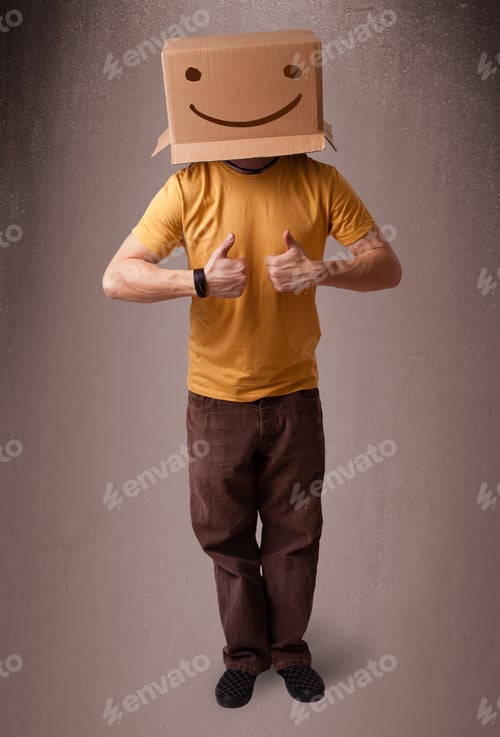 Preview: Young Man Standing And Gesturing With A Cardboard Box On His Head With Smiley Face