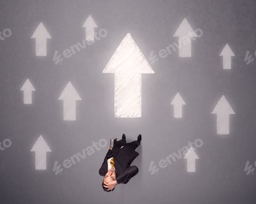Preview: Young Contemplating Businessman Stands In Front Of White Arrows