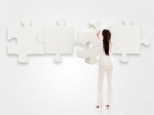 Preview: Business Woman Putting Pieces Of A Puzzle Together - Isolated Over White
