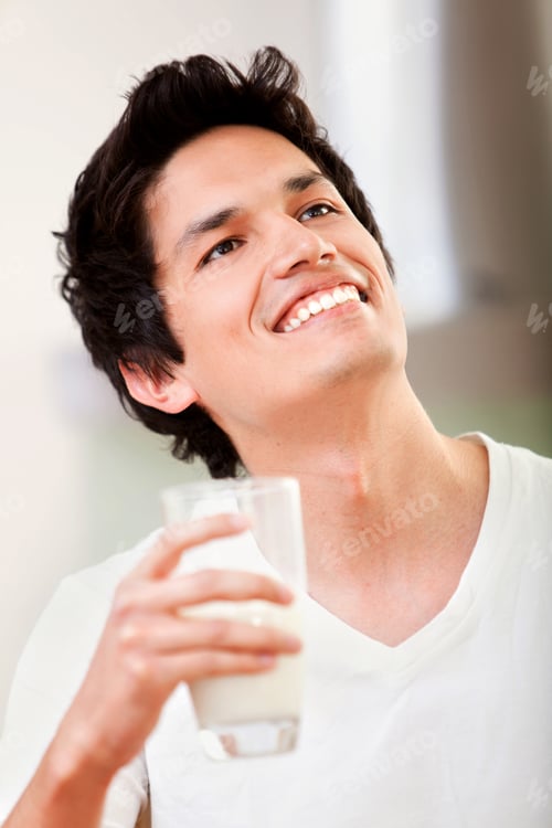 Preview: Casual Man Smiling And Drinking A Glass Of Milk