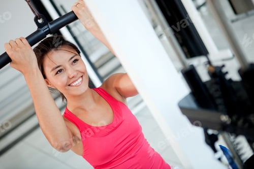 Preview: Woman Exercising Her Arms And Back At The Gym On A Machine
