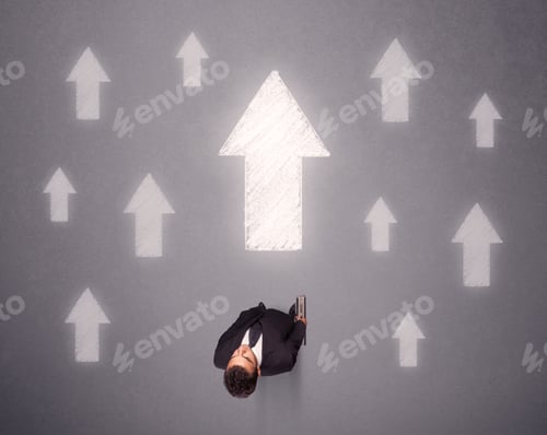 Preview: Young Contemplating Businessman Stands In Front Of White Arrows