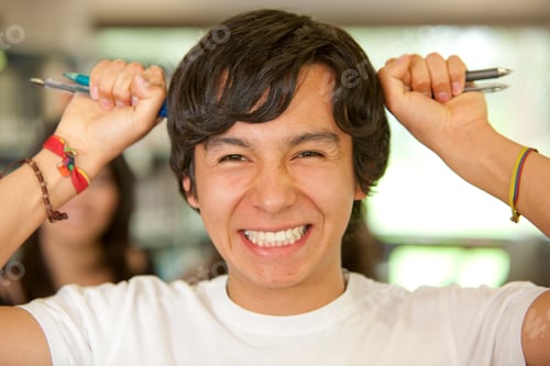 Preview: Student In A Library With Pencils On Both Sides Of His Head