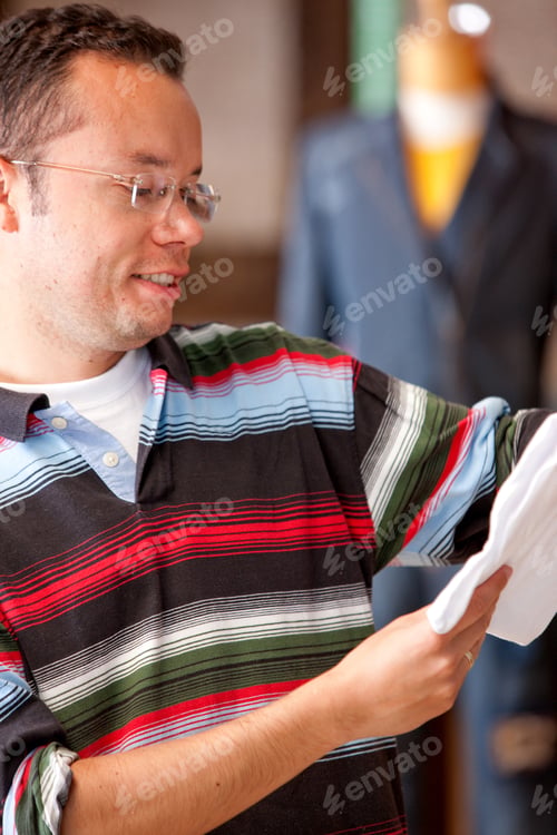 Preview: Handsome Man Looking At Some Clothes In A Shop