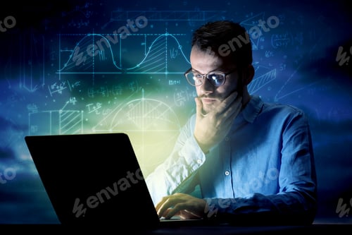 Preview: Young Handsome Businessman Working Late At Night In The Office With Blue Mathematic Charts In The