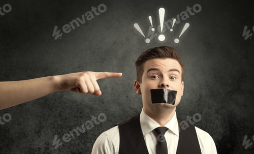 Preview: Caucasian Hand Pointing At Employee In Business Suit, With Drawn Exclamation Marks Above His Head