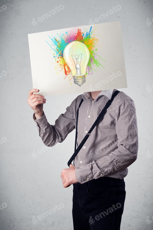 Preview: Businessman Holding A Cardboard With Coloured Paint Splashes And Lightbulb In Front Of His Head