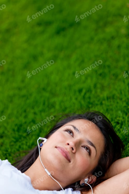 Preview: Relaxing woman listening to music in green field