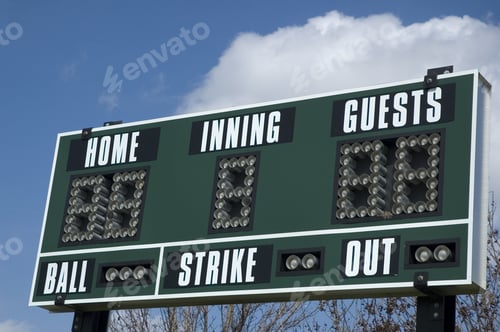 Preview: Scoreboard Above Softball Field On A Spring Day, Blue Sky And Cumulus Cloud In Background