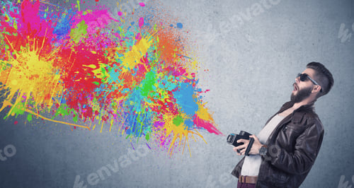 Preview: A Retro Hipster Male Taking Photograph With A Vintage Camera Of An Urban Wall With Paint Splatter