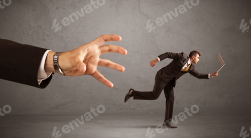 Preview: Young Miniature Businessman Running From A Big Hand With Grey Background