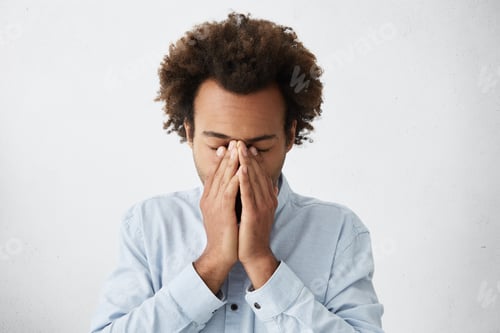 Preview: Close Up Shot Of African Man Wearing White T-Shirt Having Tired Expression Covering His Face With