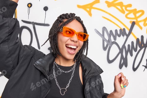 Preview: Positive Energetic Dark Skinned Teenage Girl With Dreadlocks Has Fun Dances Against Colorful